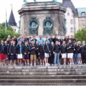 Boys and girls travel team to Europe pose outside of national monument