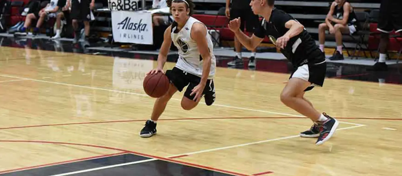 Athlete drives to basket at NBC Basketball Camp