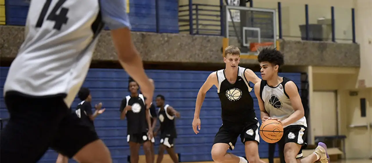 Camper drives to the basket in tournament play at NBC Basketball Camps