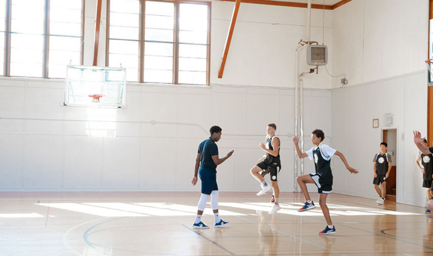 Coach training athletes for basketball camp workout