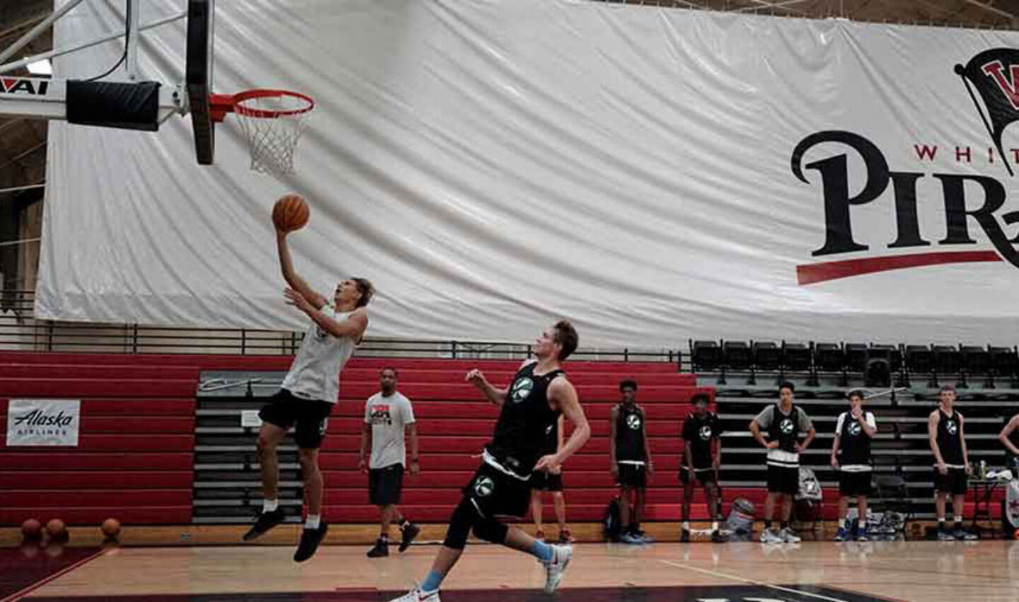 Athlete finishes the play with a run-away layup during basketball camp game.