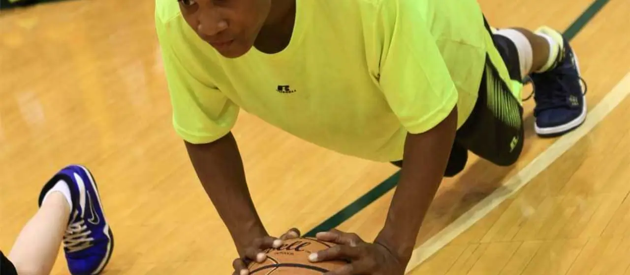 Athlete does ball pushups at basketball camp