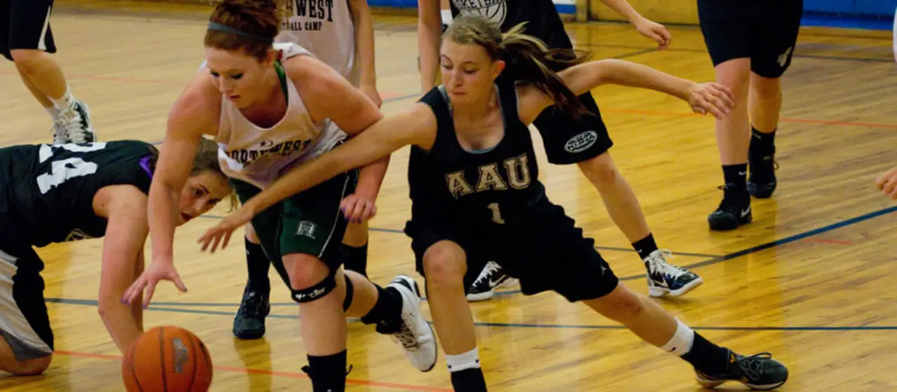 Girls basketball players scramble for the ball during a transition