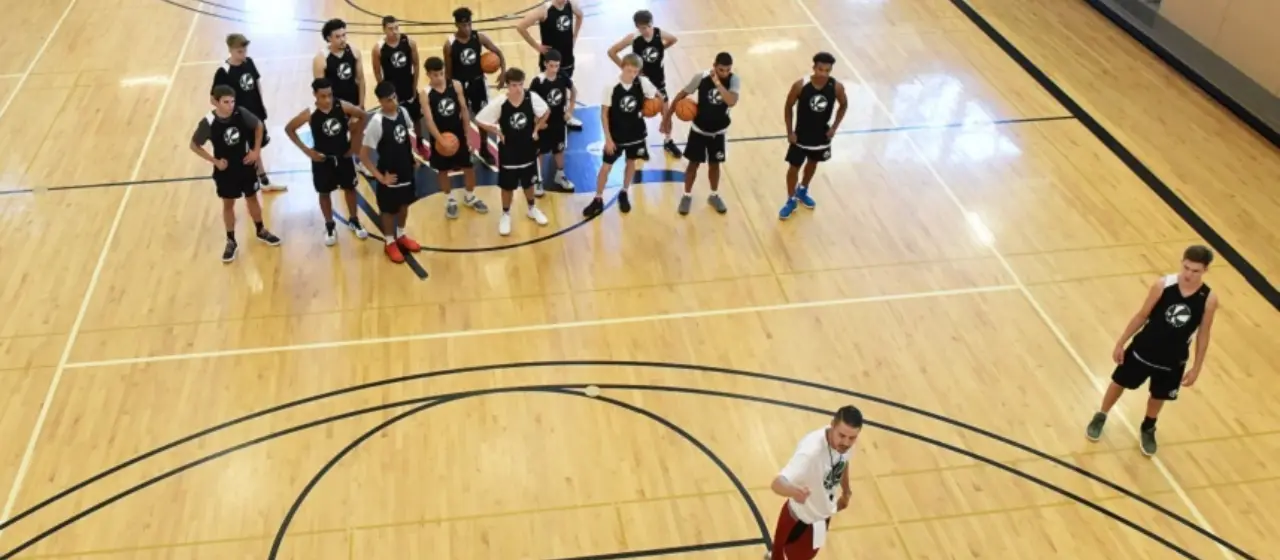 Players watch coaches demonstrate drill