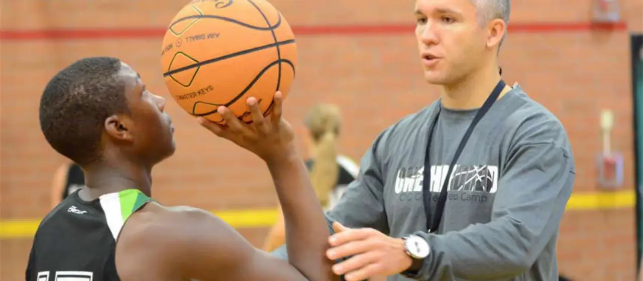 College basketball prep coach works with athlete to align shooting form for maximum accuracy