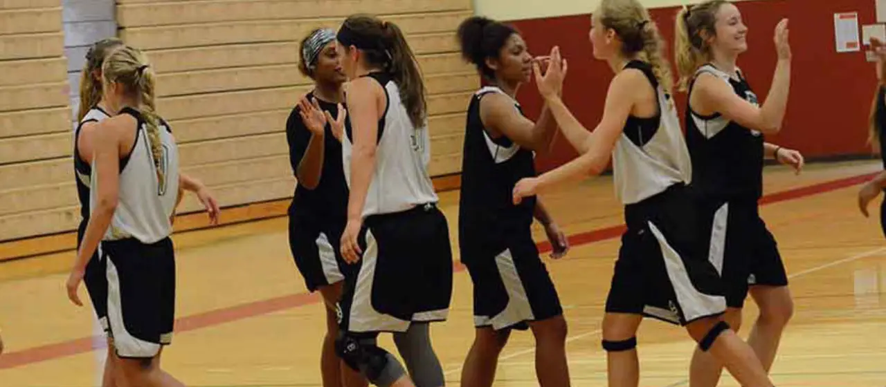 Campers give high five after basketball tournament at NBC Basketball Camp