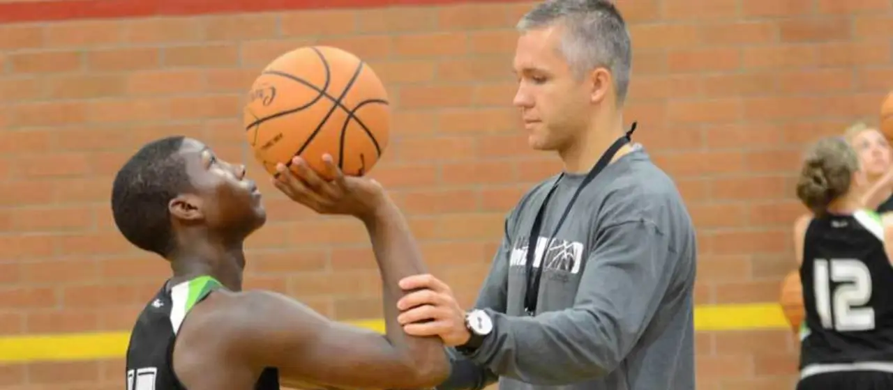 Coach adjusts the shooting arm of camper