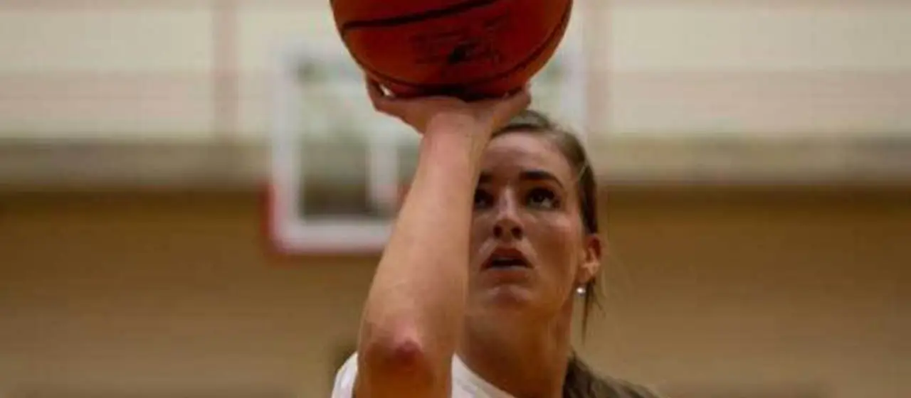 Female athlete eyes the rim during form shooting drill at NBC Basketball Camps
