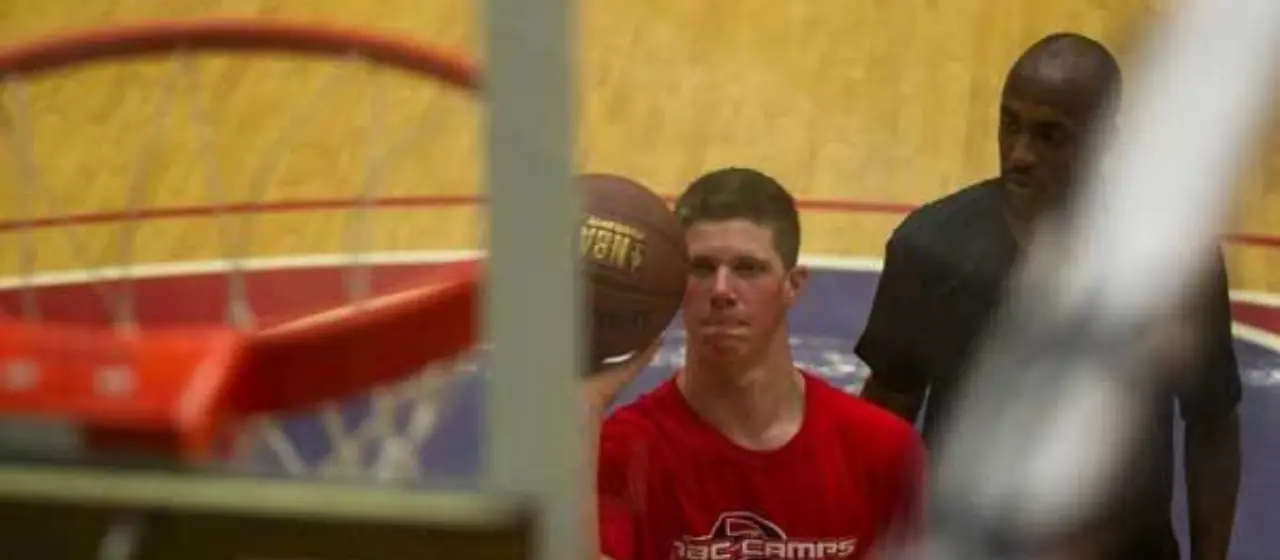 Coach gives feedback on shooting technique to basketball camper