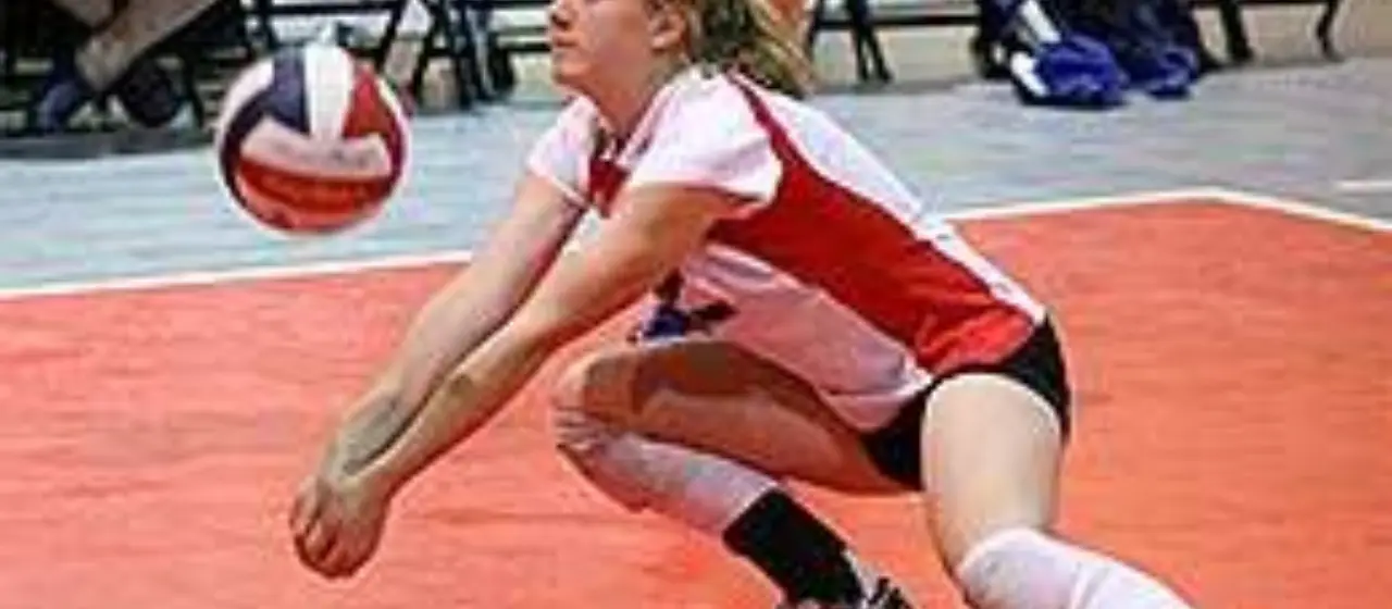 Girl stretches to bump volleyball at camp tournament game