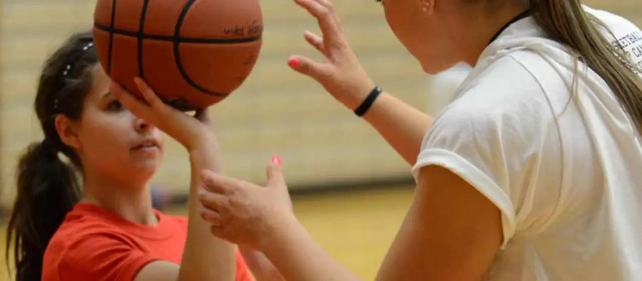 Coach works to adjust athlete's shot at NBC Basketball Camp