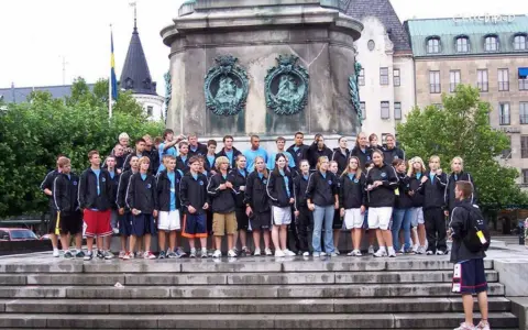 Boys and girls travel team to Europe pose outside of national monument