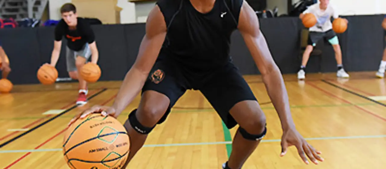 Older athletes practice using two basketballs during warm-ups