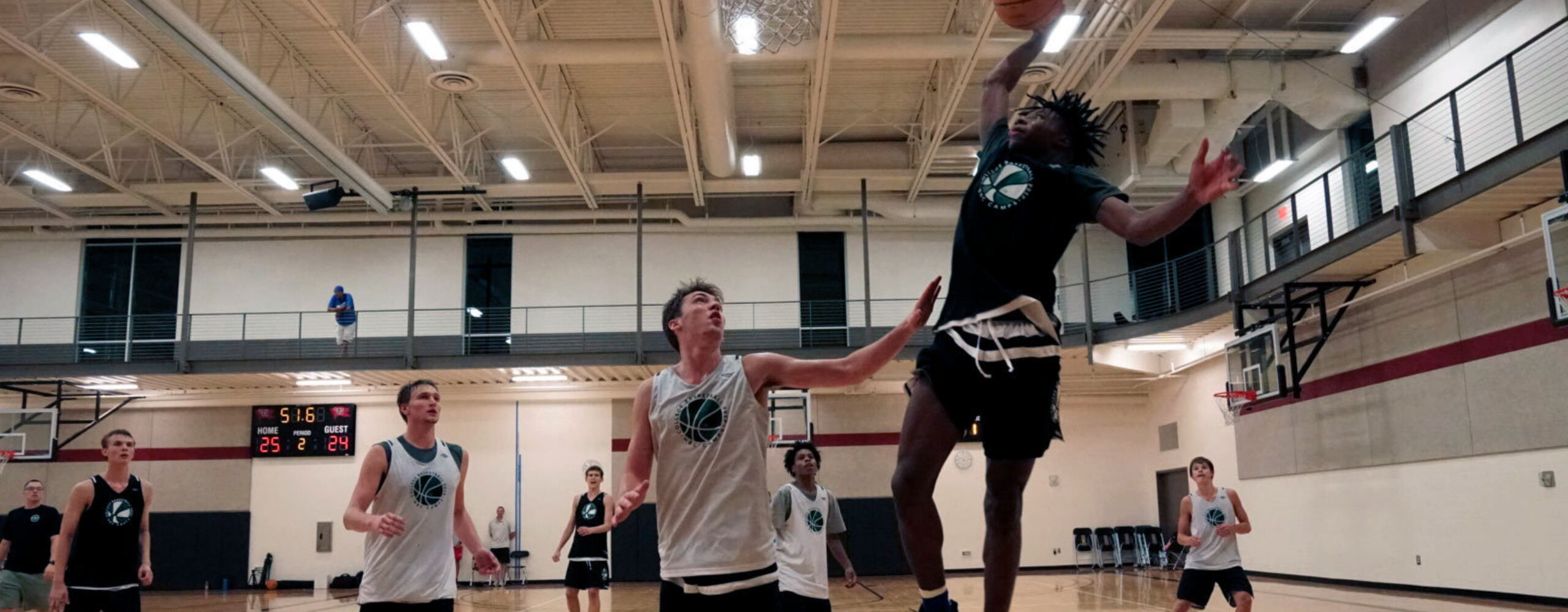 Full court scrimmage at college basketball prep camp ends with open shot.