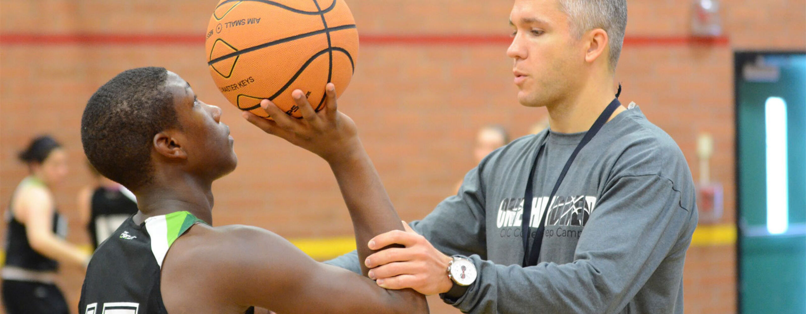 NBC Basketball Coach adjusts players shooting form for optimum accuracy in pure shooting camp